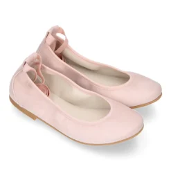 Bailarina niña tipo Ballet con cintas elásticas en piel ante pastel.