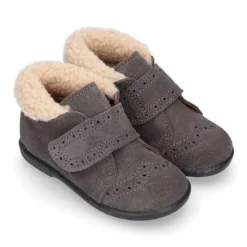 Botita clásica niños sin cordones tipo Blucher en piel serraje con picados y cuello de borreguito.