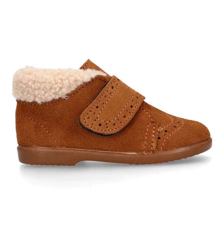 Botita clásica niños sin cordones tipo Blucher en piel serraje con picados y cuello de borreguito.