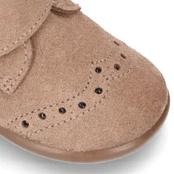 Botita clásica sin cordones tipo Blucher en piel serraje con picados.