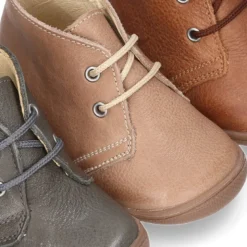 Botita con puntera, talonera y cordones en piel para pequeños.