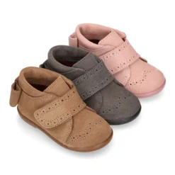 Botita niña sin cordones con lazo y picados en piel serraje.