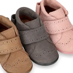 Botita niña sin cordones con lazo y picados en piel serraje.