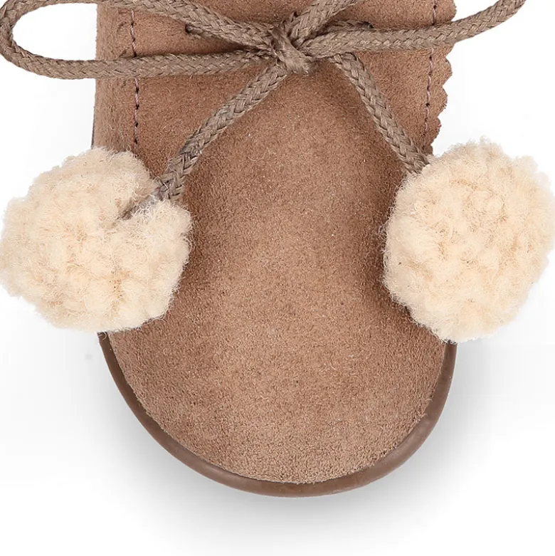 Botita niños con pompones y cuello borreguito en piel serraje.