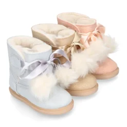 Botitas tipo Australianas niña con diseño con POMPONES en piel serraje metalizado.
