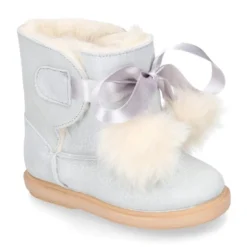 Botitas tipo Australianas niña con diseño con POMPONES en piel serraje metalizado.
