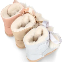 Botitas tipo Australianas niña con diseño con POMPONES en piel serraje metalizado.