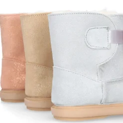 Botitas tipo Australianas niña con diseño con POMPONES en piel serraje metalizado.