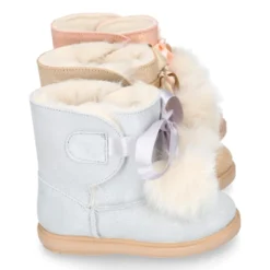 Botitas tipo Australianas niña con diseño con POMPONES en piel serraje metalizado.