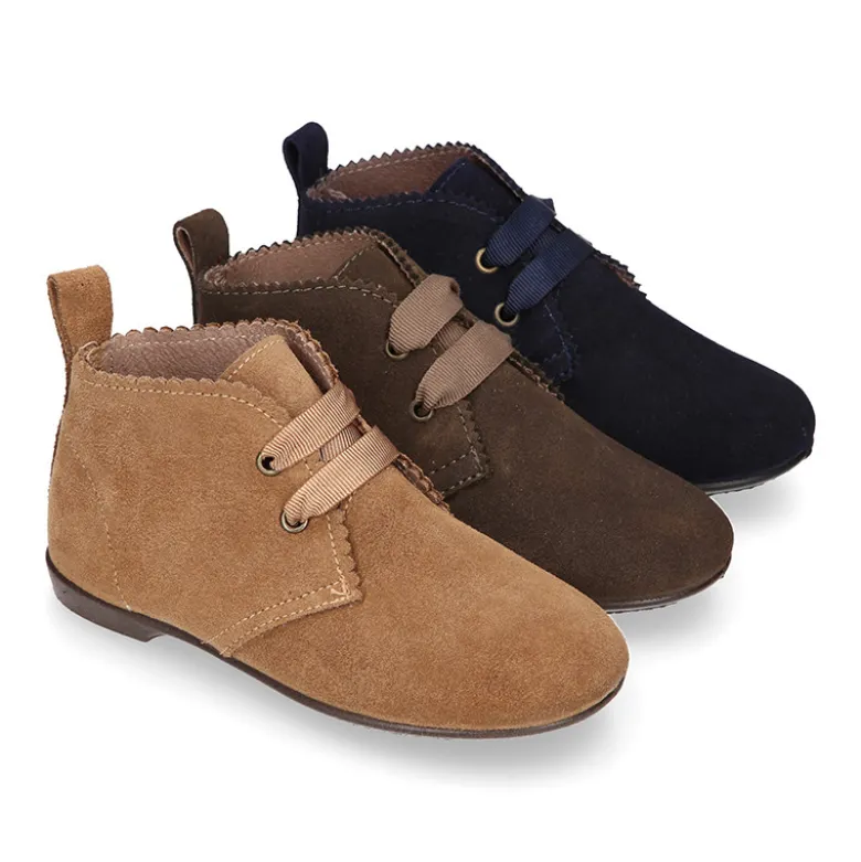 Botín tipo blucher con ondas y lazos en piel serraje.