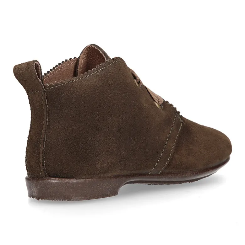 Botín tipo blucher con ondas y lazos en piel serraje.