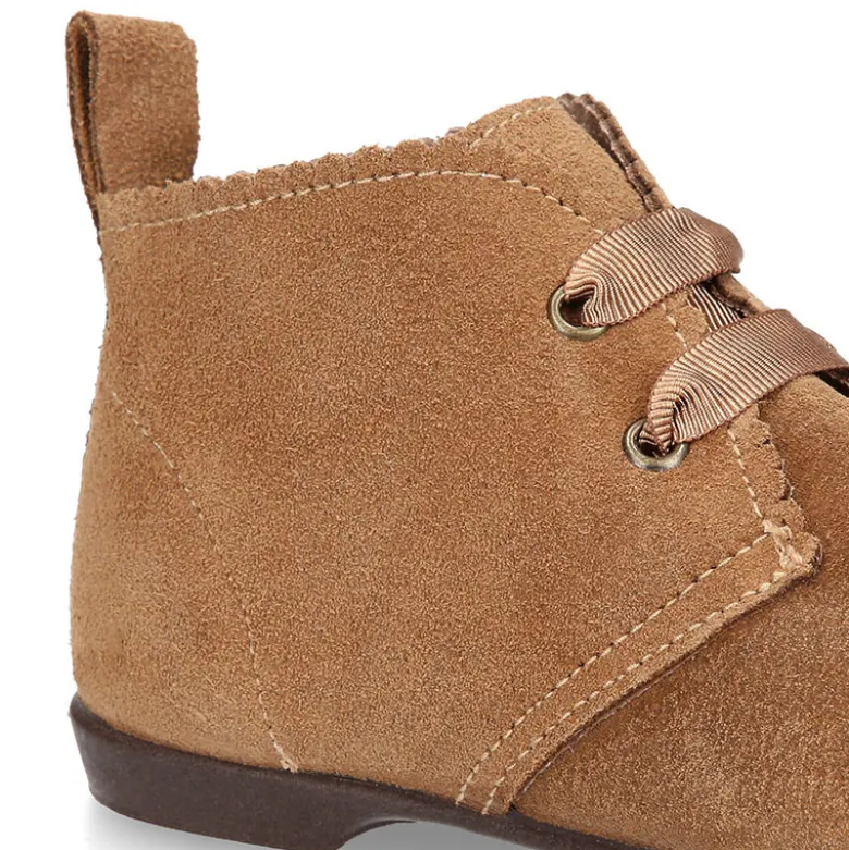 Botín tipo blucher con ondas y lazos en piel serraje.