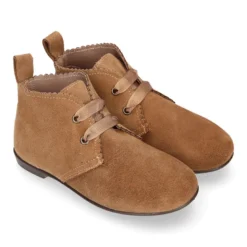 Botín tipo blucher con ondas y lazos en piel serraje.