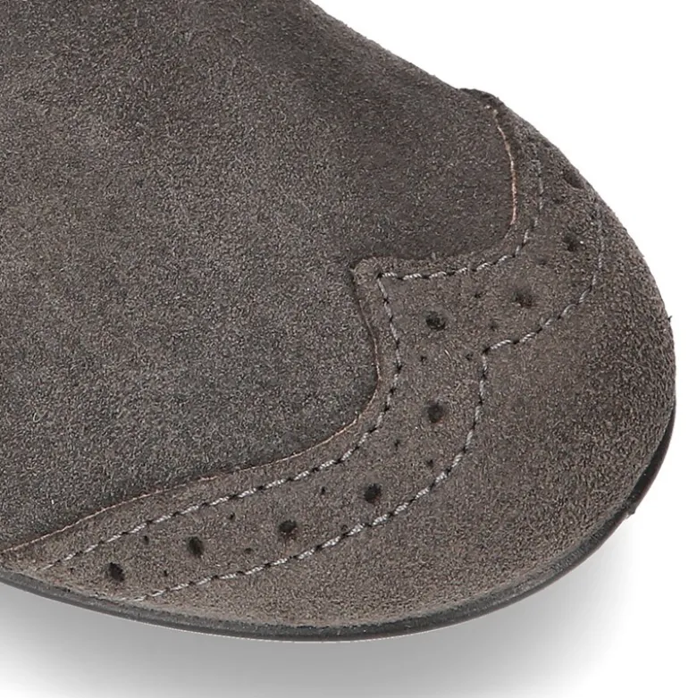 Botín tipo BLUCHER con picados y lazos en piel serraje.
