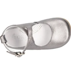 Mercedita abotinada con tiras cruzadas en piel metalizada.