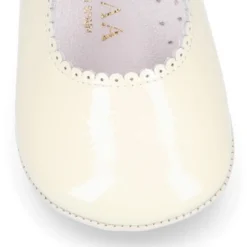 Mercedita bebé con botón y festón en piel charol.