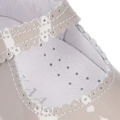 Mercedita bebé con botón y festón en piel charol.