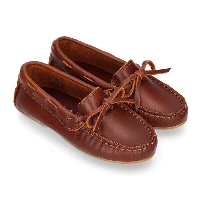 Mocasín niño clásico con diseño con lazos en piel cuero.