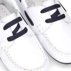 Náutico en piel napa blanca con cordones y suela en marino para niños.