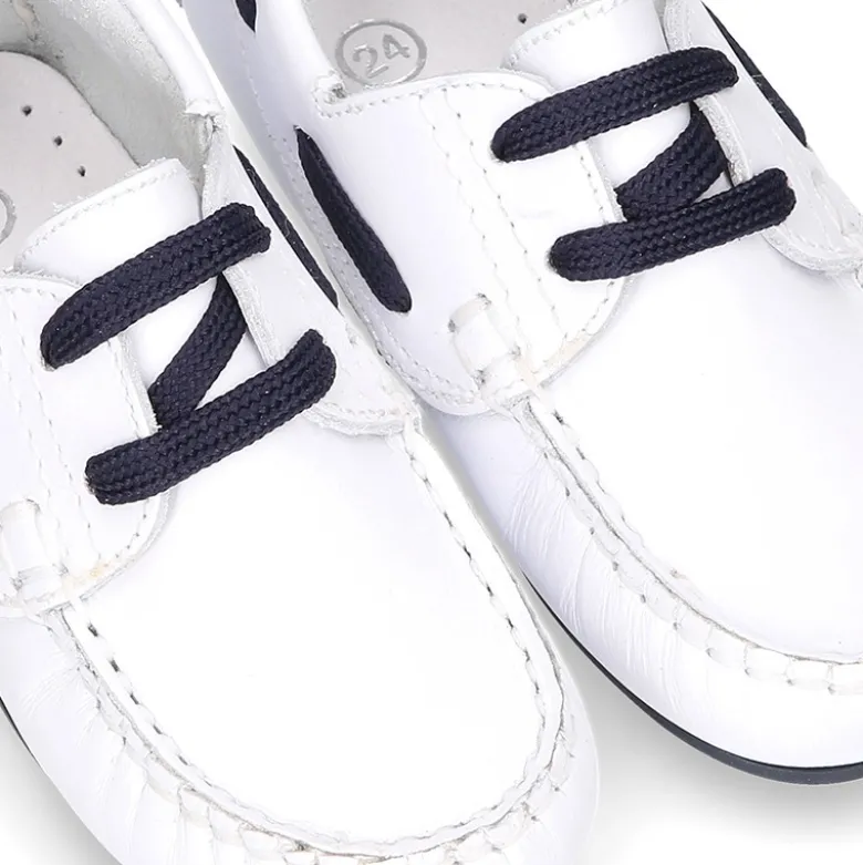 Náutico en piel napa blanca con cordones y suela en marino para niños.