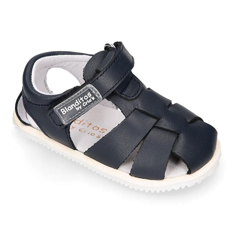 Sandalia niño Blanditos by Crio’s tiras cruzadas y sin cordones en piel en colores clásicos.