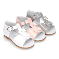 Sandalia peques en forma de T con dos lazos y perlas en piel charol.