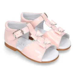 Sandalia peques en forma de T con dos lazos y perlas en piel charol.