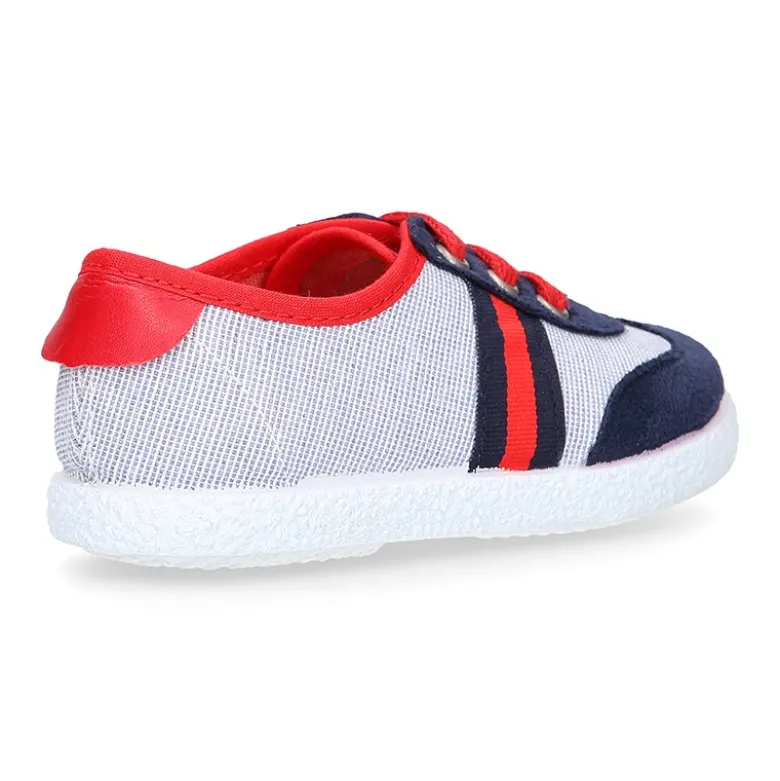 Tenis niño combinado en lona con cordones.