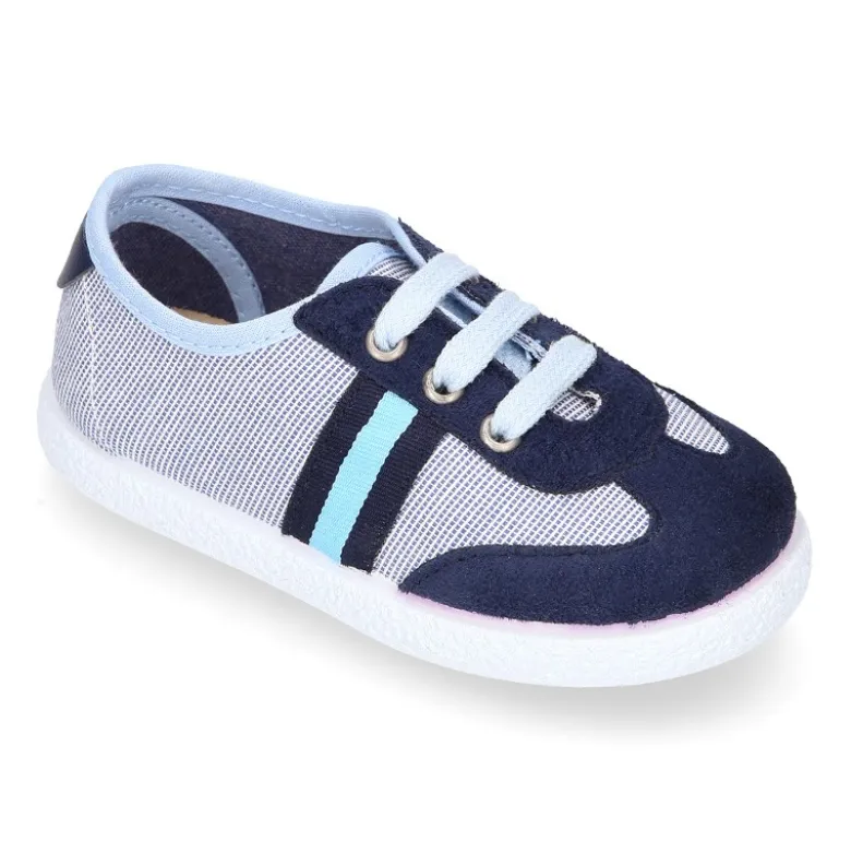 Tenis niño combinado en lona con cordones.