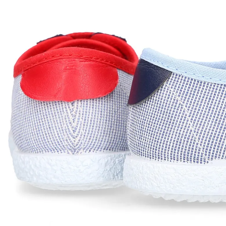 Tenis niño combinado en lona con cordones.