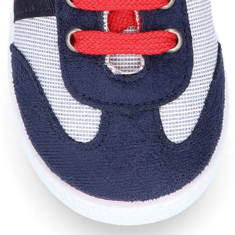 Tenis niño combinado en lona con cordones.