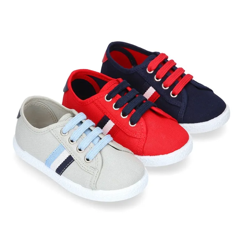 Tenis niño con cordones en lona con bandera.
