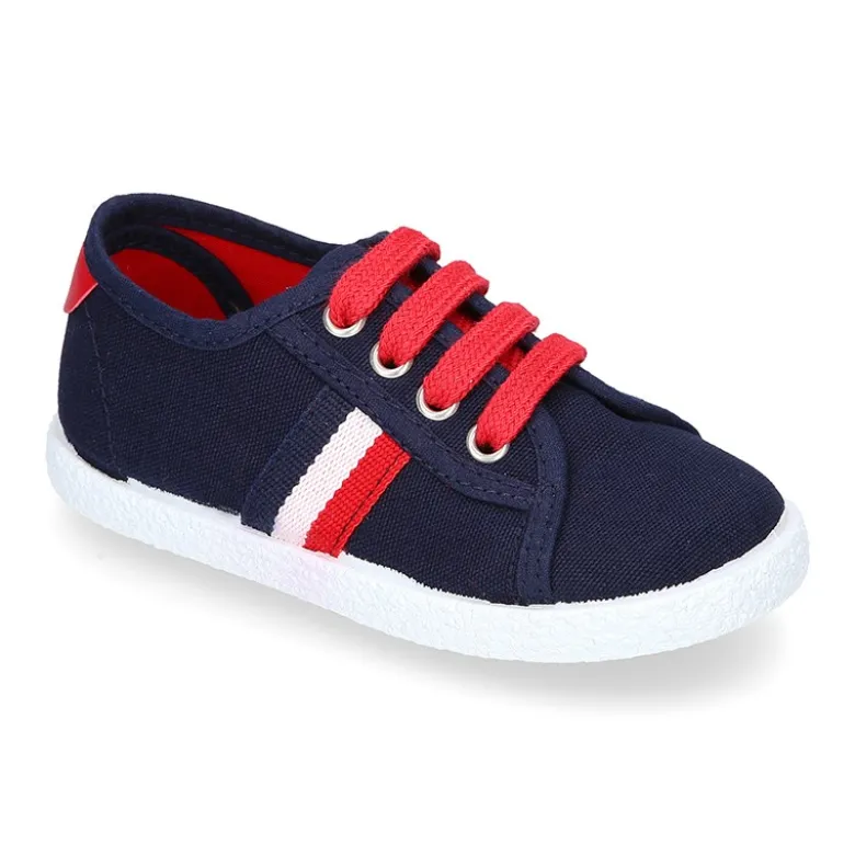 Tenis niño con cordones en lona con bandera.