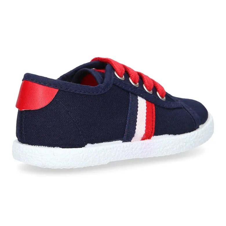 Tenis niño con cordones en lona con bandera.