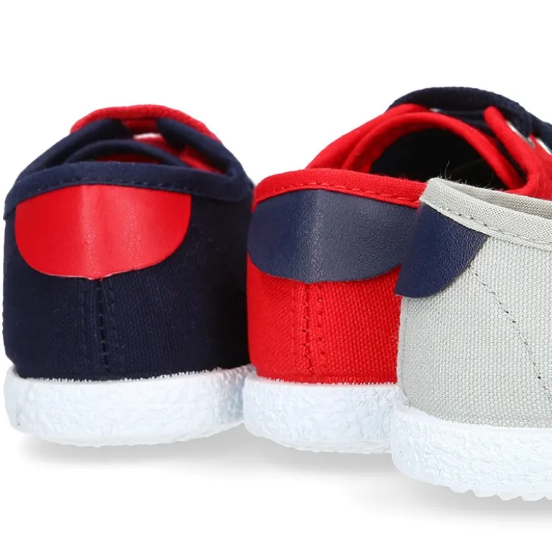 Tenis niño con cordones en lona con bandera.
