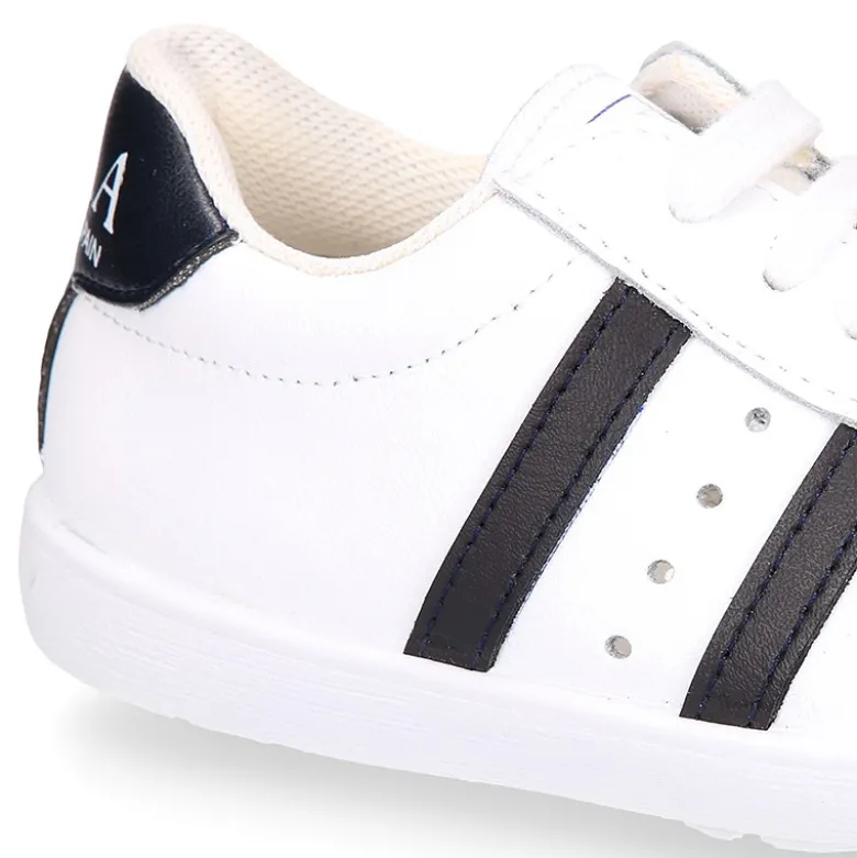 Zapatilla niños colegial OKAA con cordones, rayas laterales y puntera reforzada en piel lavable.