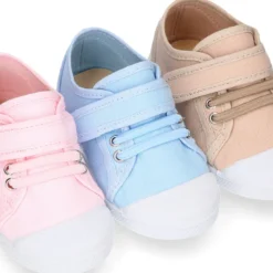 Zapatilla niños con puntera y cordones elásticos en lona en colores pastel.