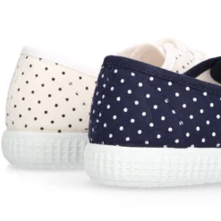 Zapatilla tipo bamba con cordones y lunares.