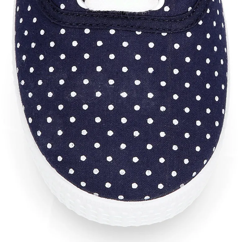 Zapatilla tipo bamba con cordones y lunares.