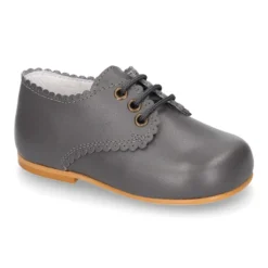 Zapatito clásico tipo BLUCHER con festón en piel napa.
