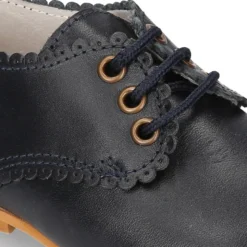 Zapatito clásico tipo BLUCHER con festón en piel napa.
