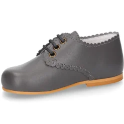 Zapatito clásico tipo BLUCHER con festón en piel napa.