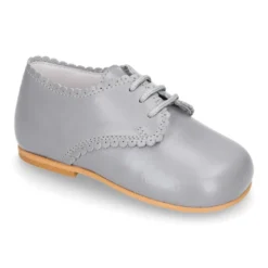 Zapatito clásico tipo BLUCHER con festón en piel napa.