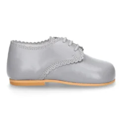 Zapatito clásico tipo BLUCHER con festón en piel napa.