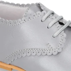 Zapatito clásico tipo BLUCHER con festón en piel napa.