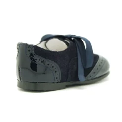 Zapatito tipo Blucher con lazos y picados en piel serraje con charol.