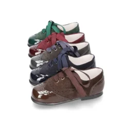 Zapatito tipo Blucher con lazos y picados en piel serraje con charol.