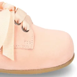 Zapatito tipo Blucher con lazo en piel ante suave en colores pasteles.