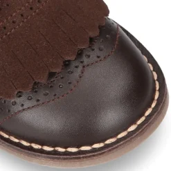 Zapatito tipo blucher con lengüeta con flecos y picados en piel combinada.