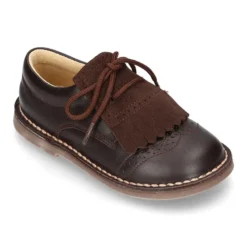 Zapatito tipo blucher con lengüeta con flecos y picados en piel combinada.